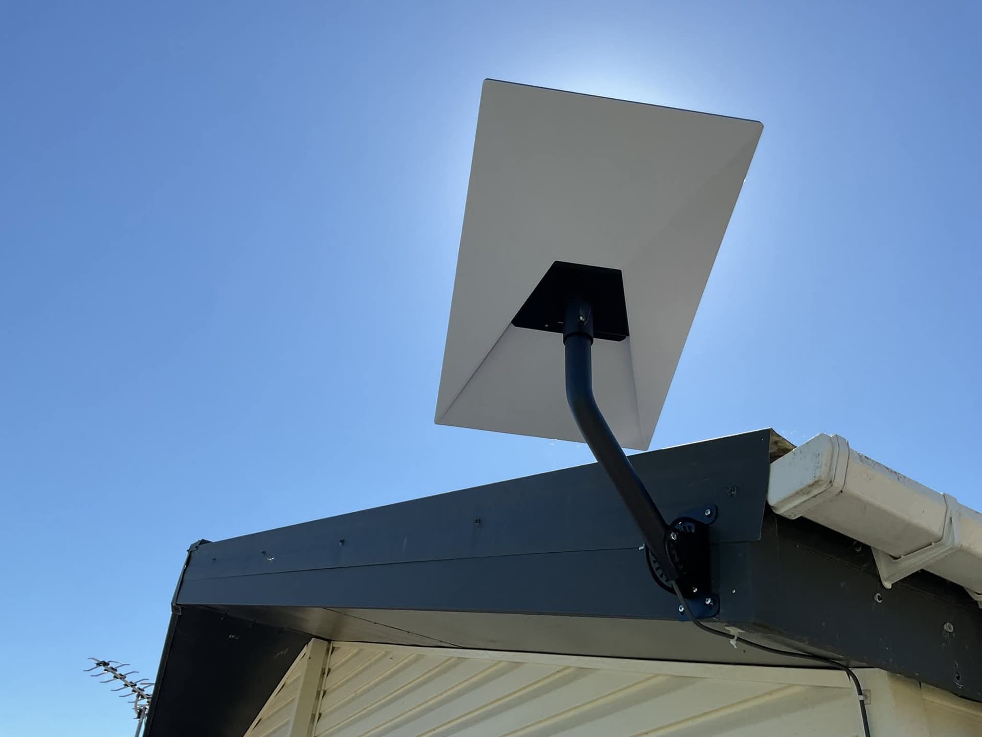 Starlink dish installed on a roof under clear sky